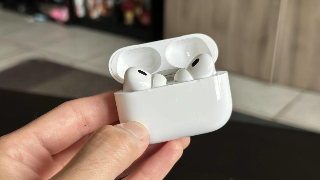 image of someone holding the charging case with two airpod pros in it