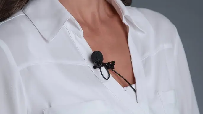 image of a woman wearing a white blouse with a lavalier lapel microphone clipped onto it